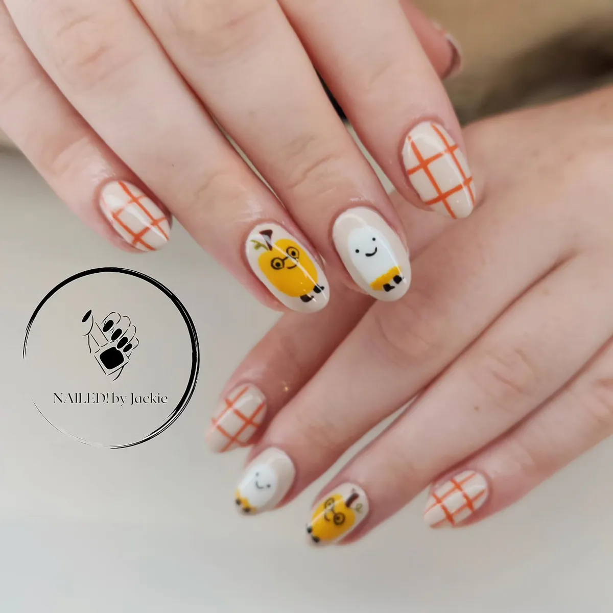 Orange grid nails with cartoon character accents