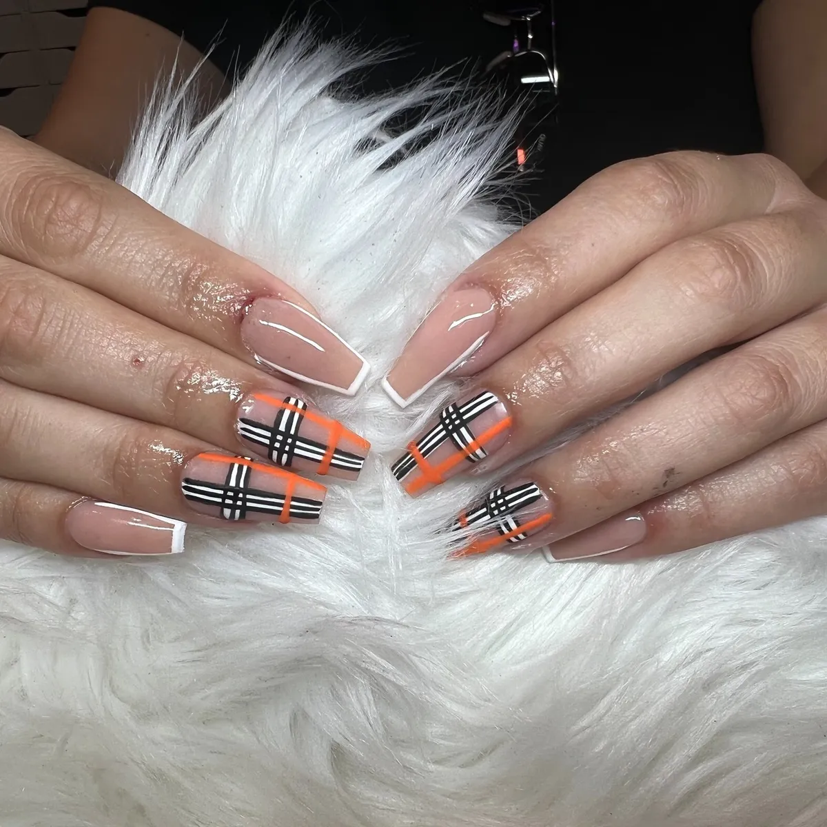 Nude outline nails with high-contrast orange plaid accents