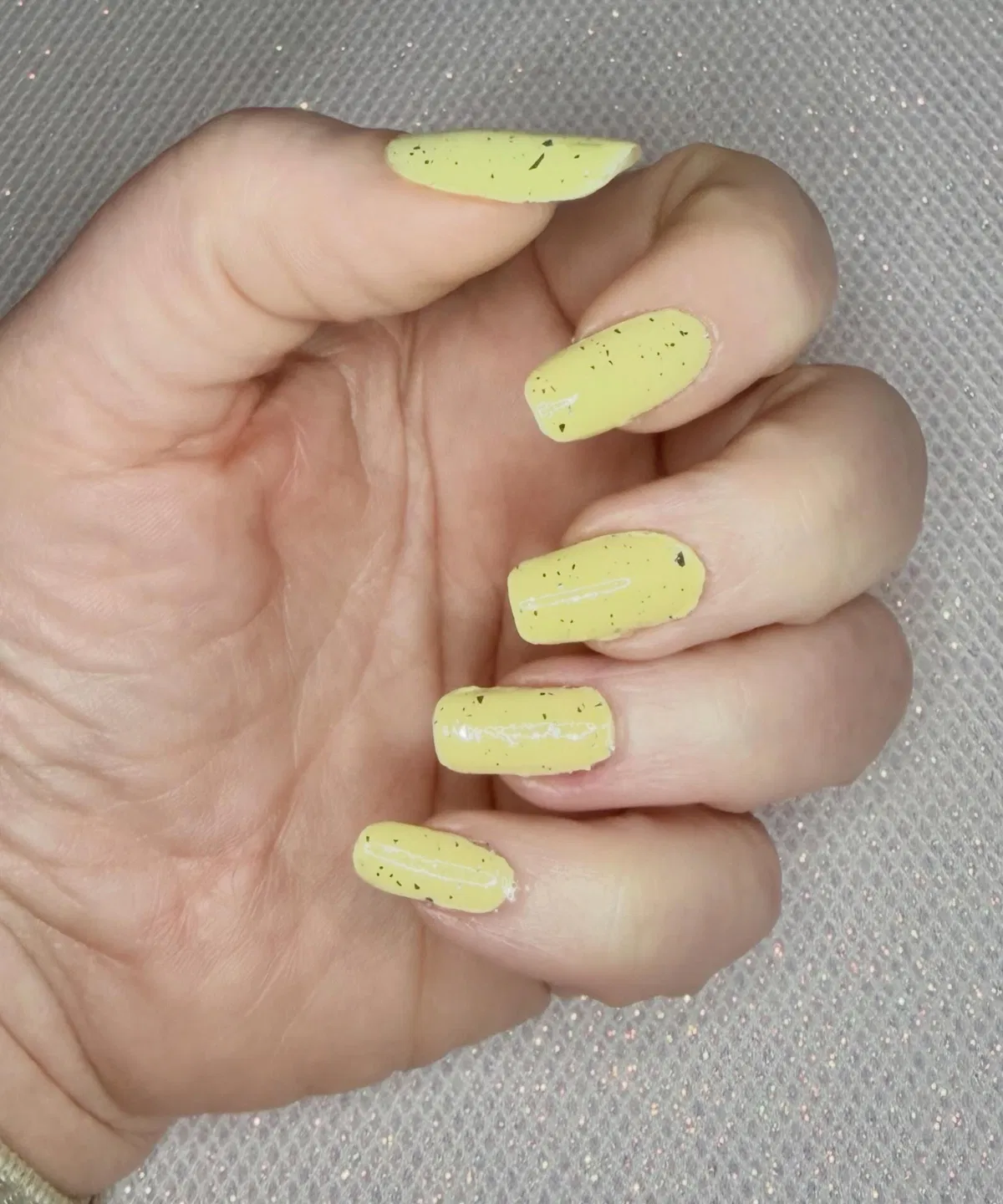 Speckled pale yellow glossy nails