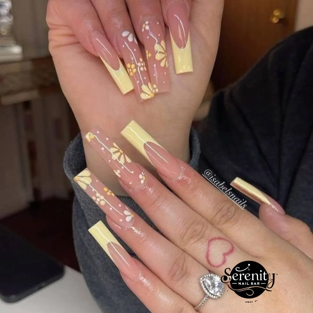 Extra-long pale yellow French tips with delicate floral details