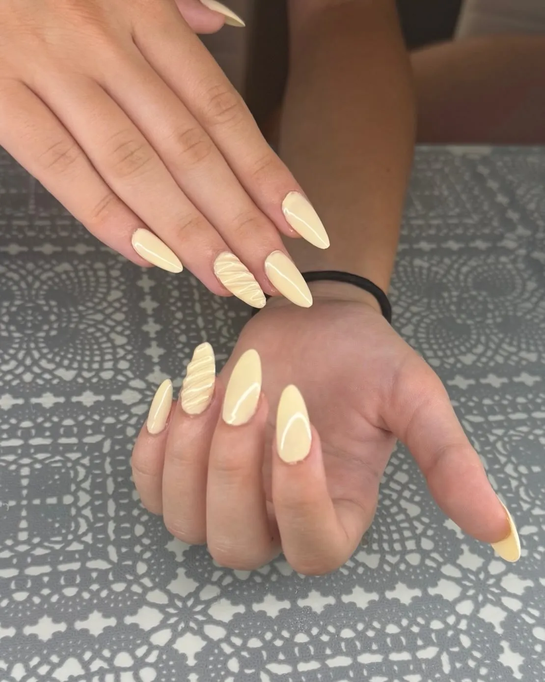 Long pale yellow nails with wavy textured accents