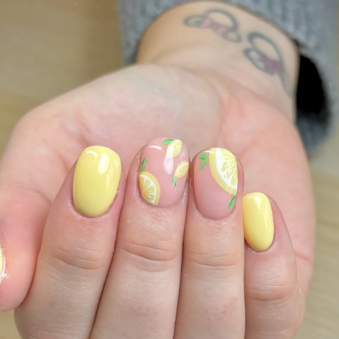 Pastel yellow solids with lemon slice nail art