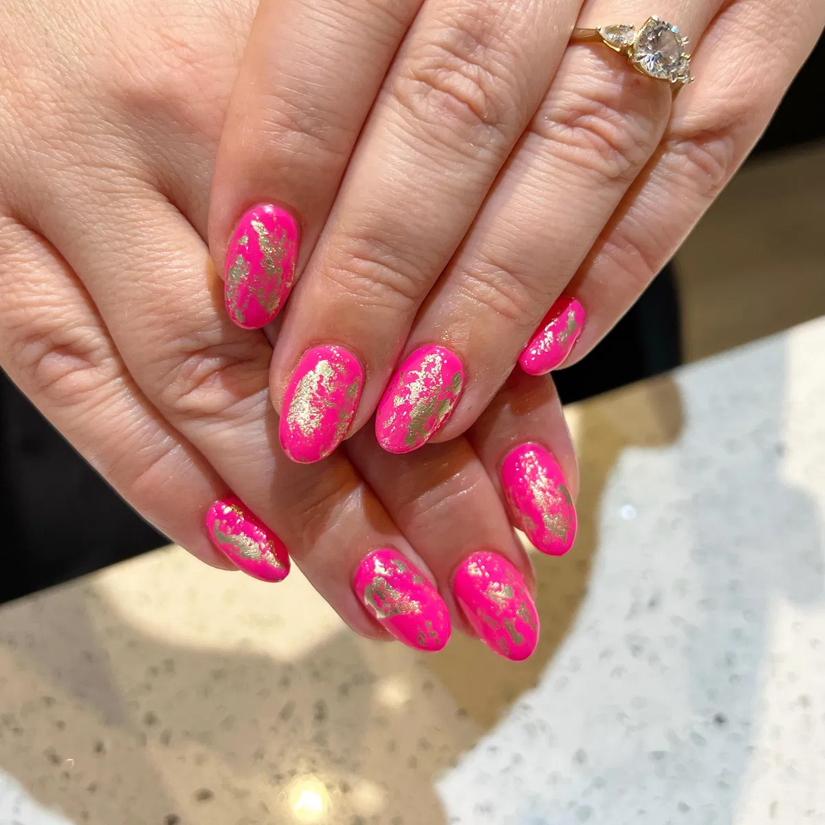 Hot pink nails with irregular gold patch accents