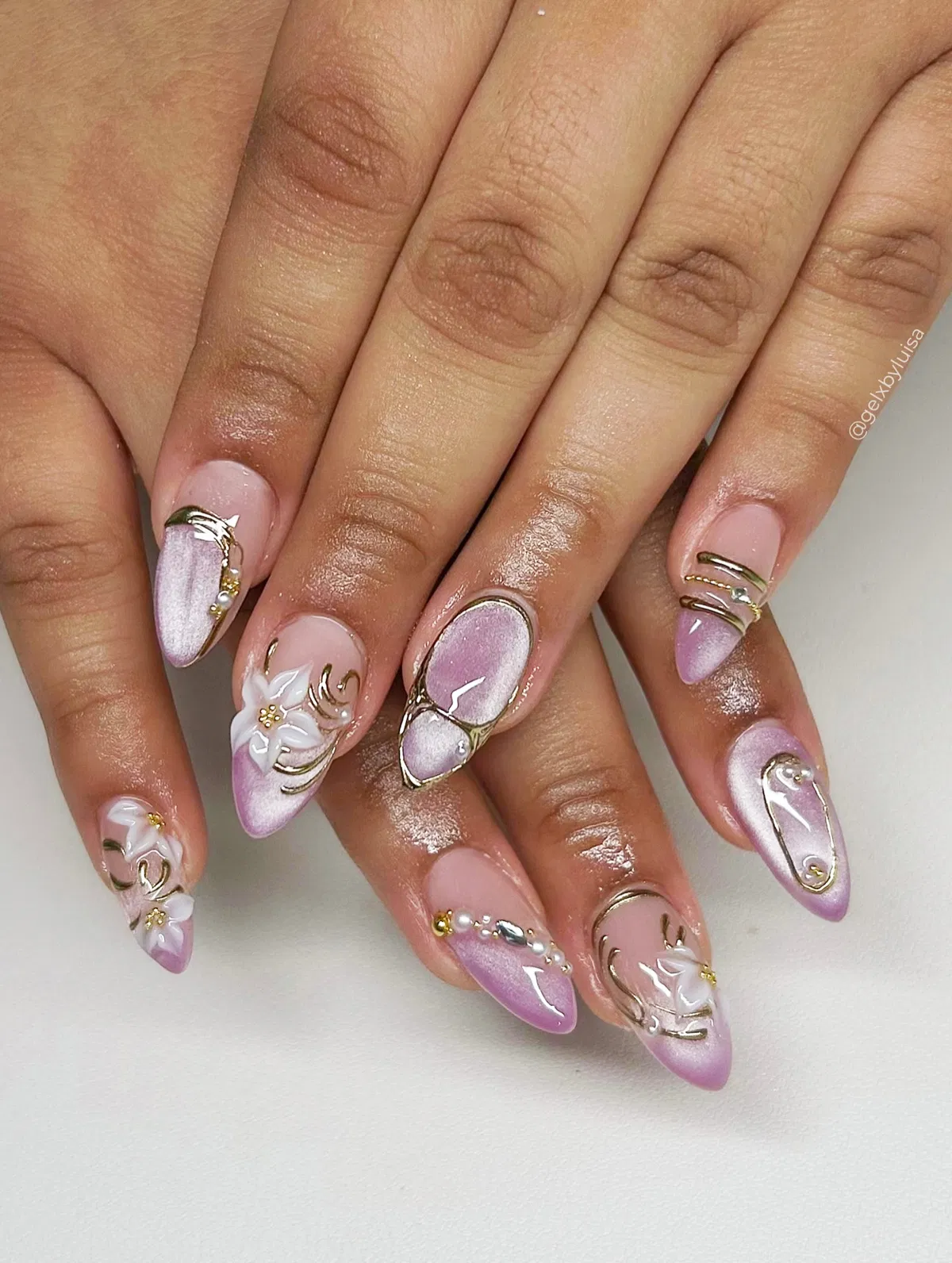 Soft pink-lavender gradients with raised gold lines and white floral accents