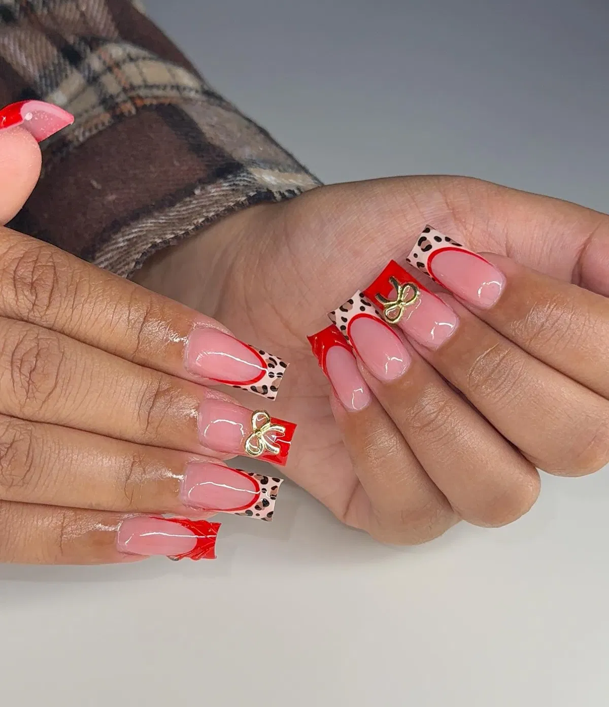 Red-outlined tips with spot accents and bow charms