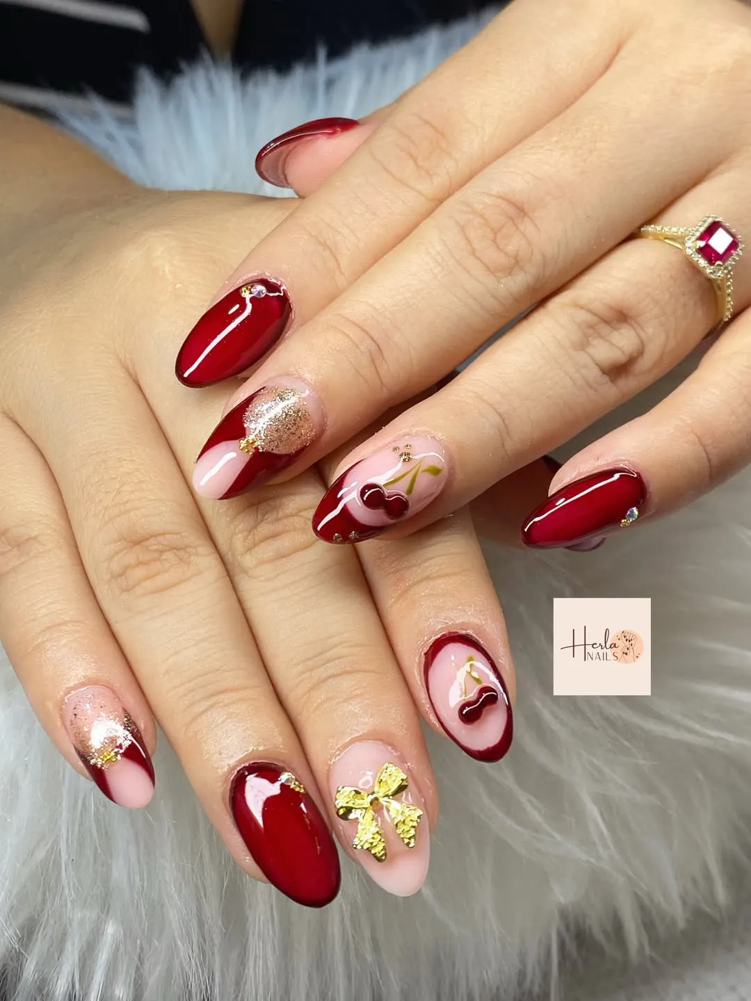 Red diagonal tips with cherry accents and a gold bow charm
