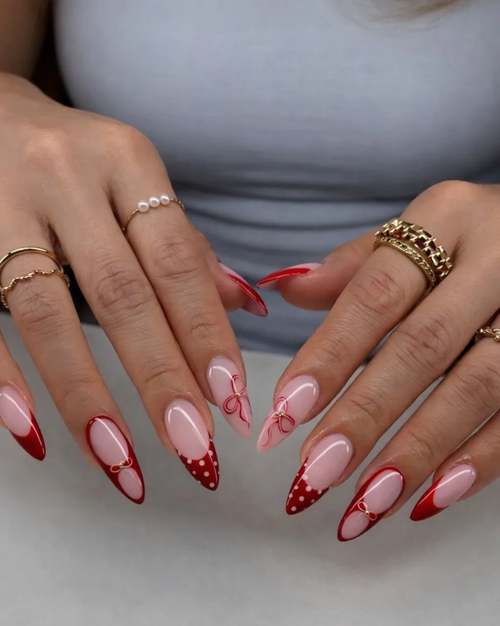 Long nude-and-red French tips with bow line art and small gold bows