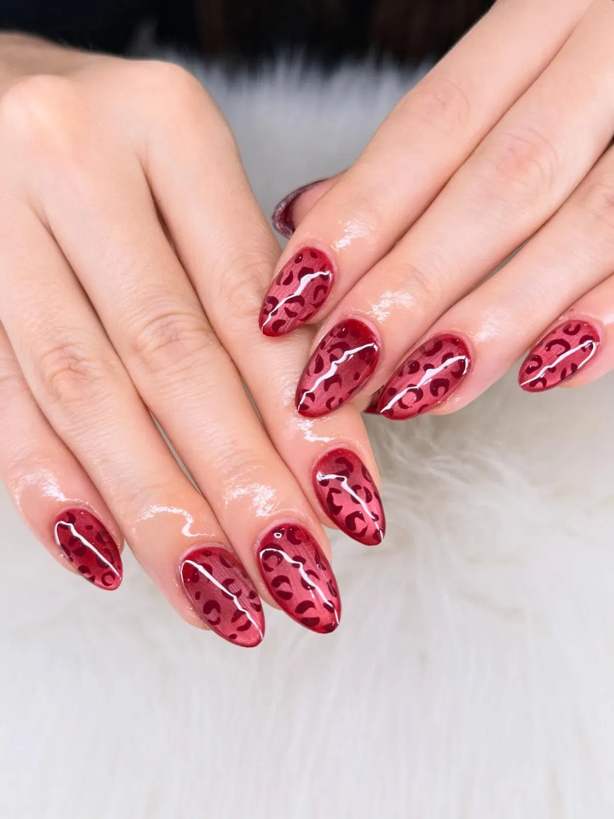 Glossy red leopard-print almond nails