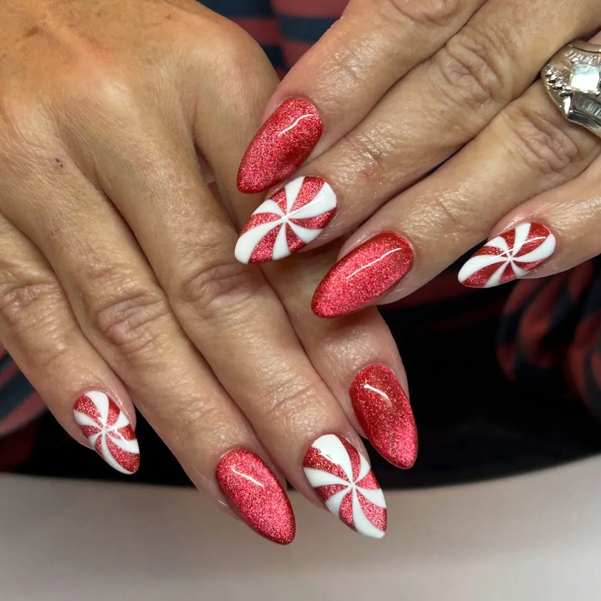 Red shimmer nails with peppermint swirl accents