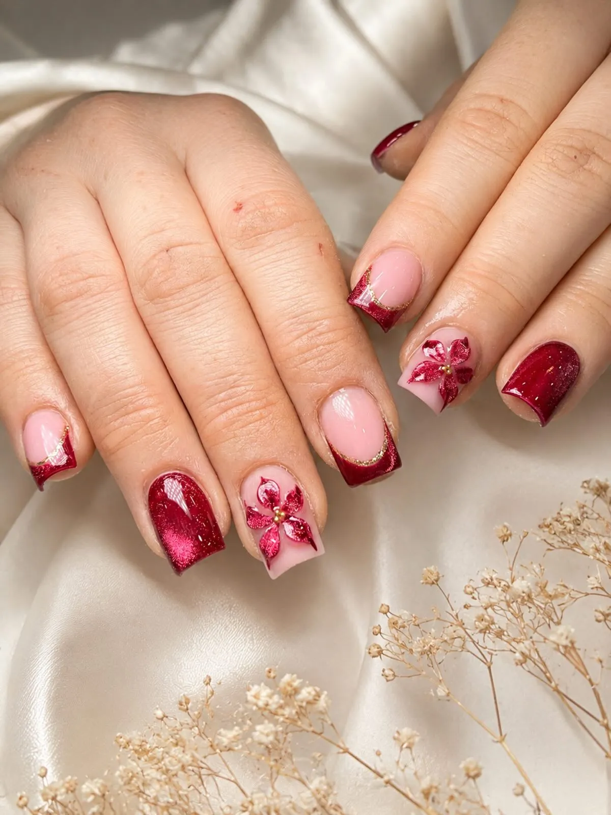 Red glitter French tips with gold edging and floral accents