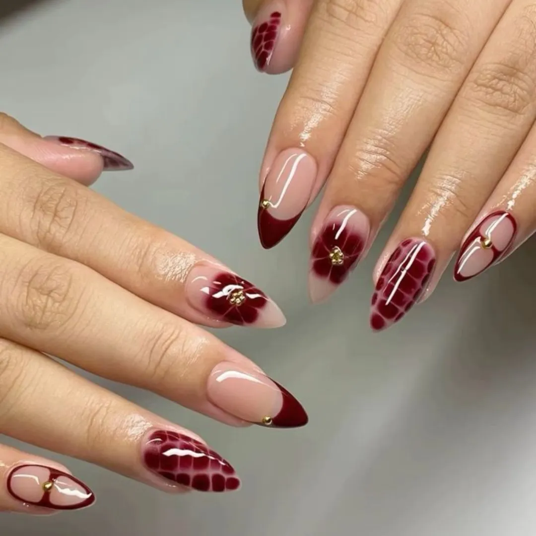 Nude base with deep red tips, florals, and scale-pattern accents