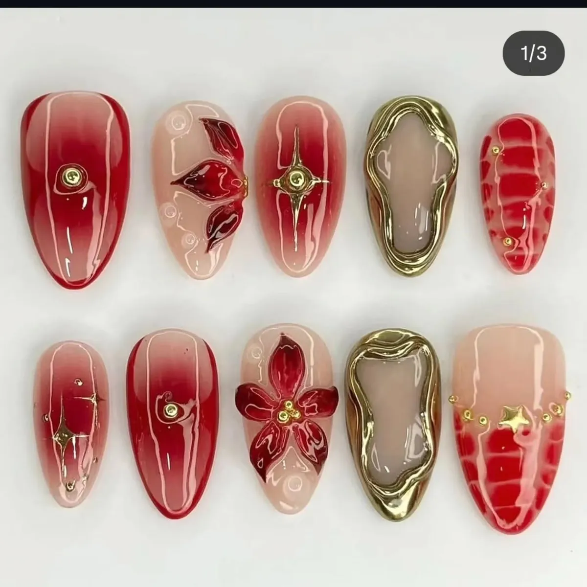 Red ombrรฉ tips with gold frames and studs