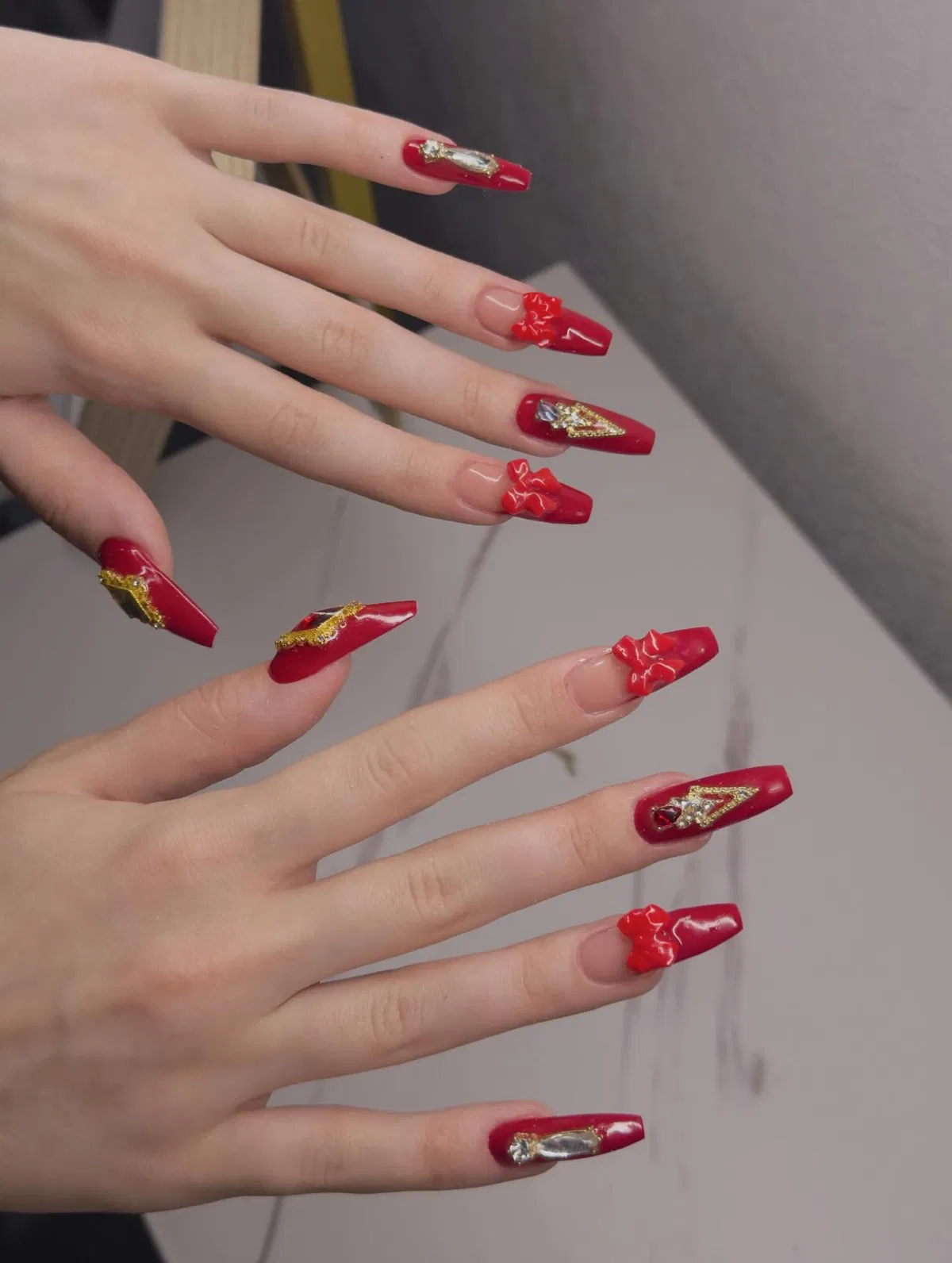 Glossy red coffin nails with 3D bows and gold foil accents