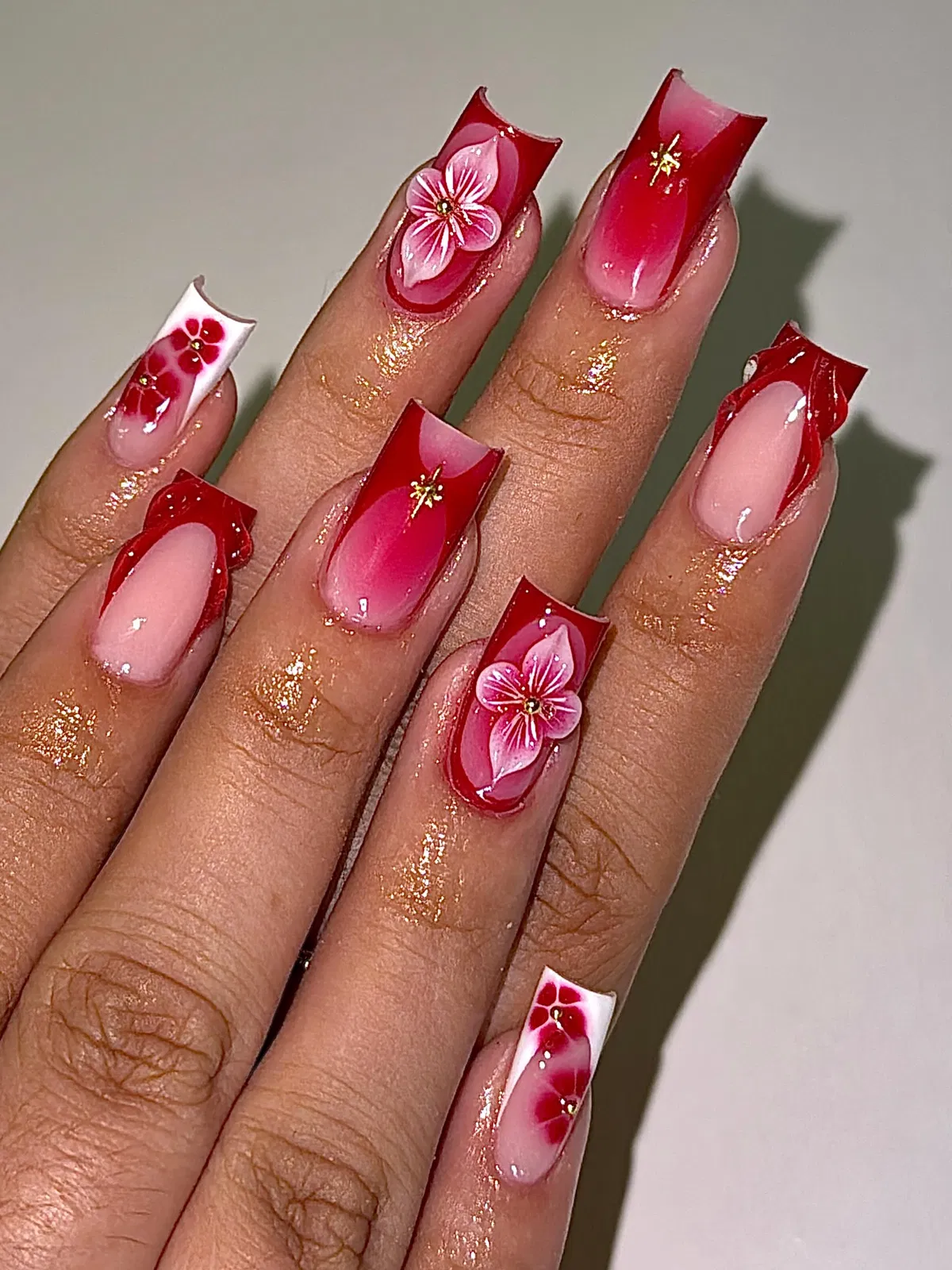 Red French tips with pink 3D flowers and gold accents