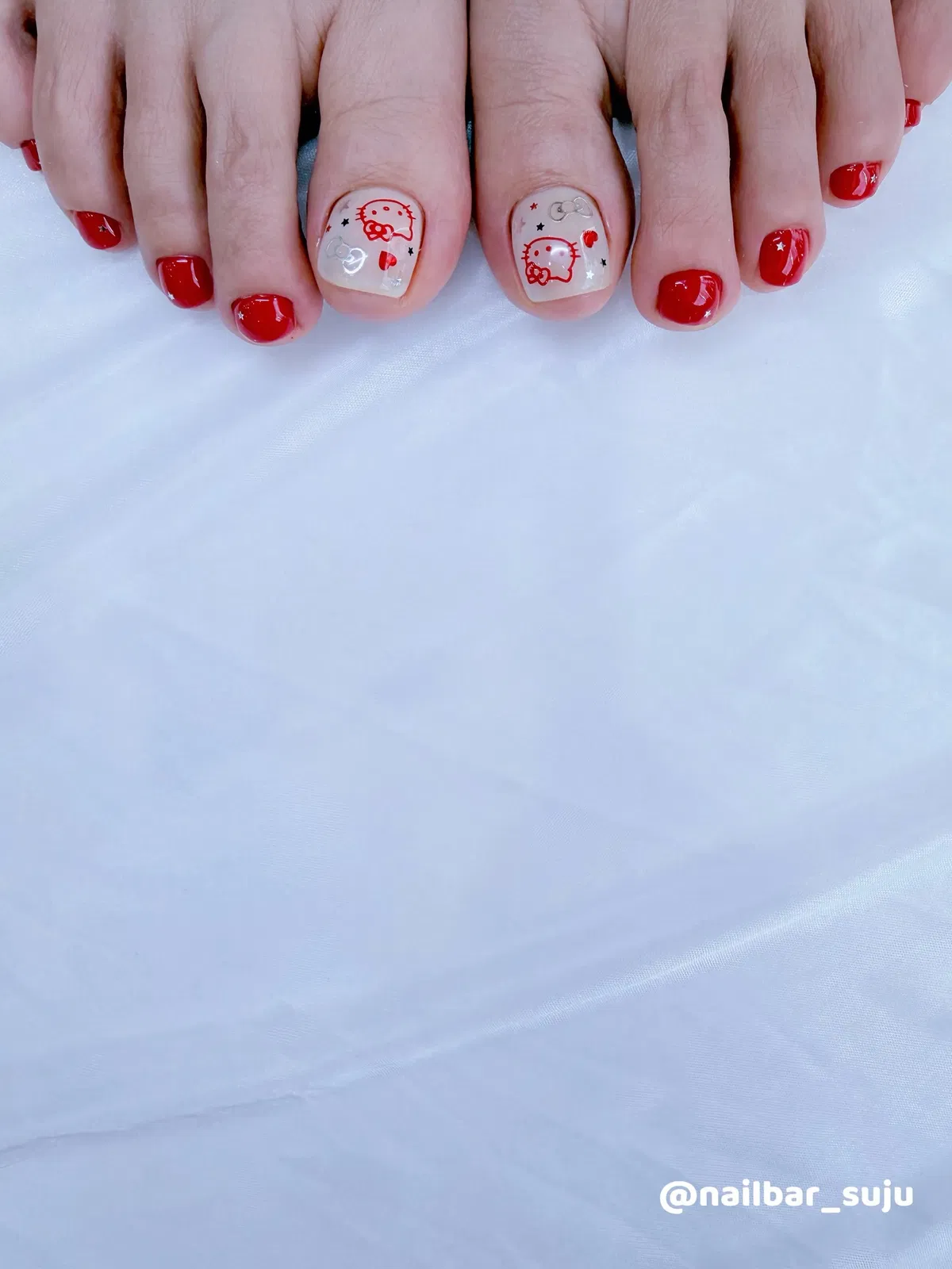 Red pedicure with cartoon-style accent big toes