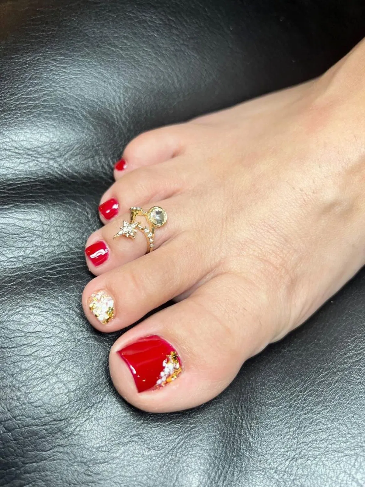 Glossy Red Toe Nails with Embellishments and a Star Toe Ring