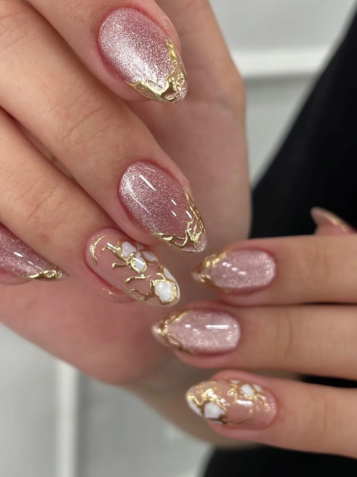 Rose shimmer nails with gold edging and branch-like accents