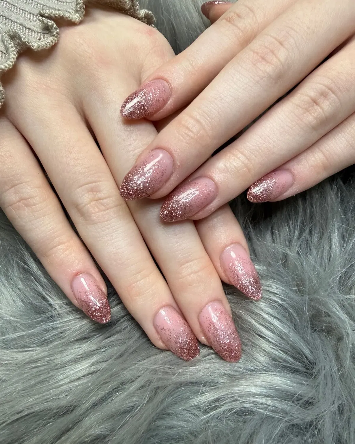 Rose-gold glitter ombré tips on glossy pink almond nails