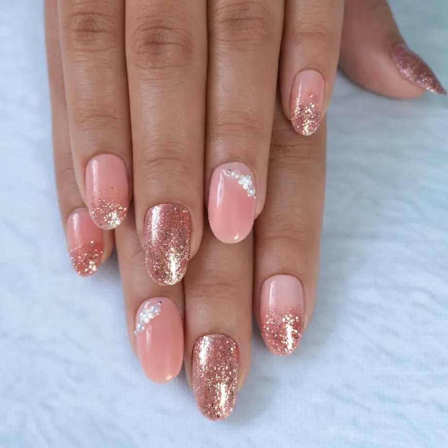 Pink nails with rose-gold glitter ombré and bead accents