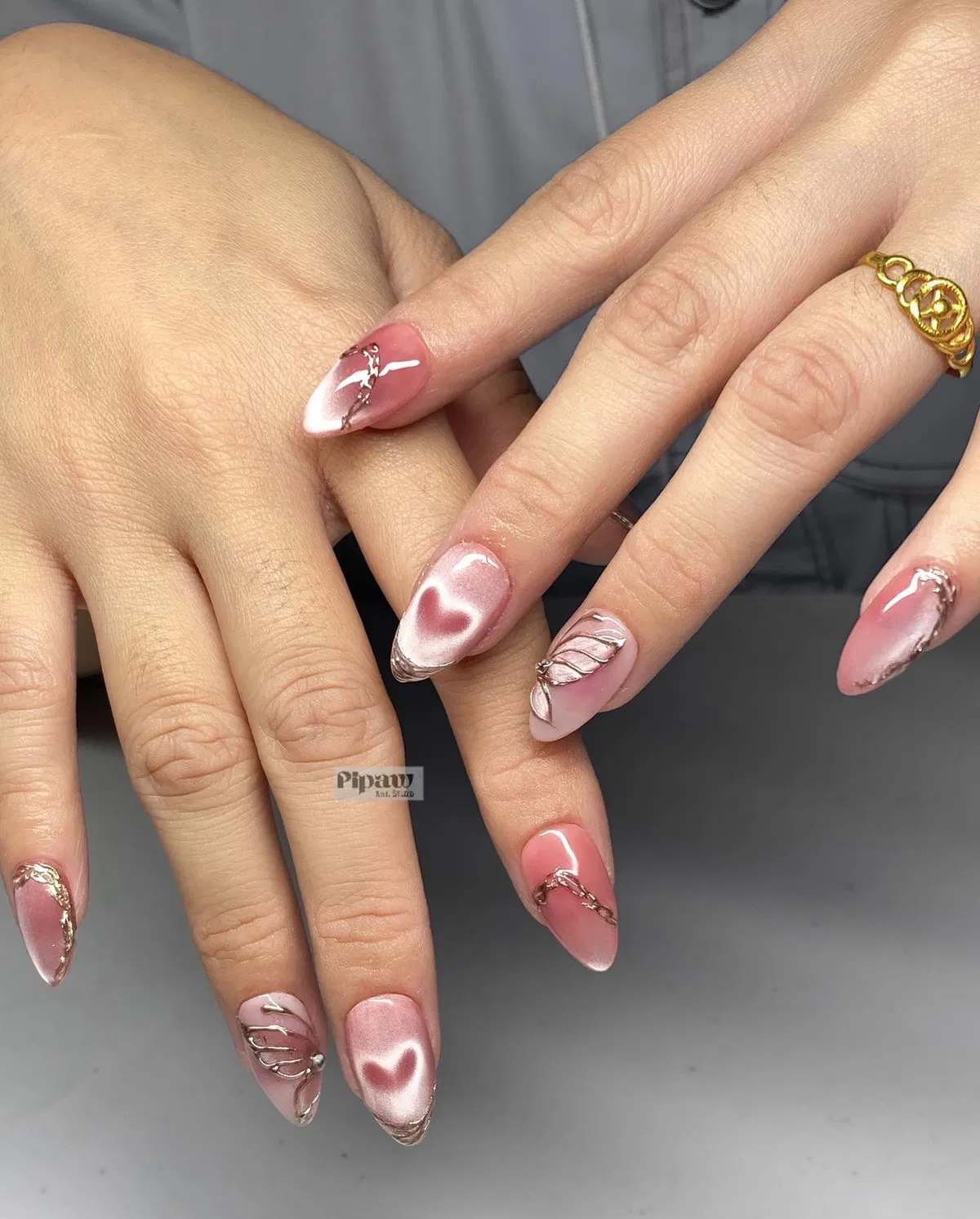 Pink glossy nails with reflective hearts and raised metallic line art