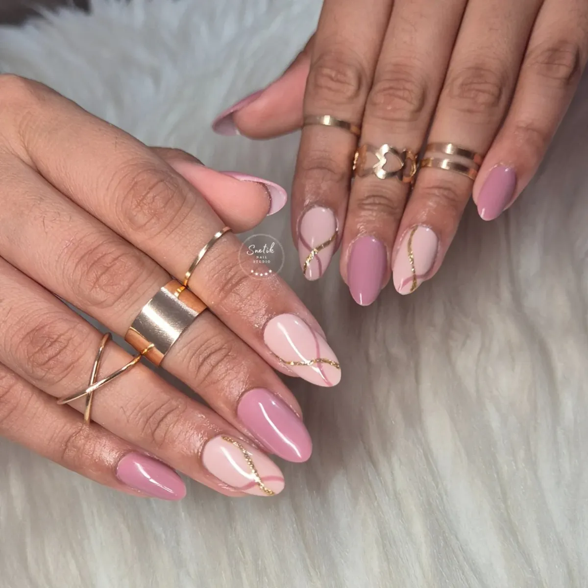 Mauve and nude almond nails with wavy gold striping
