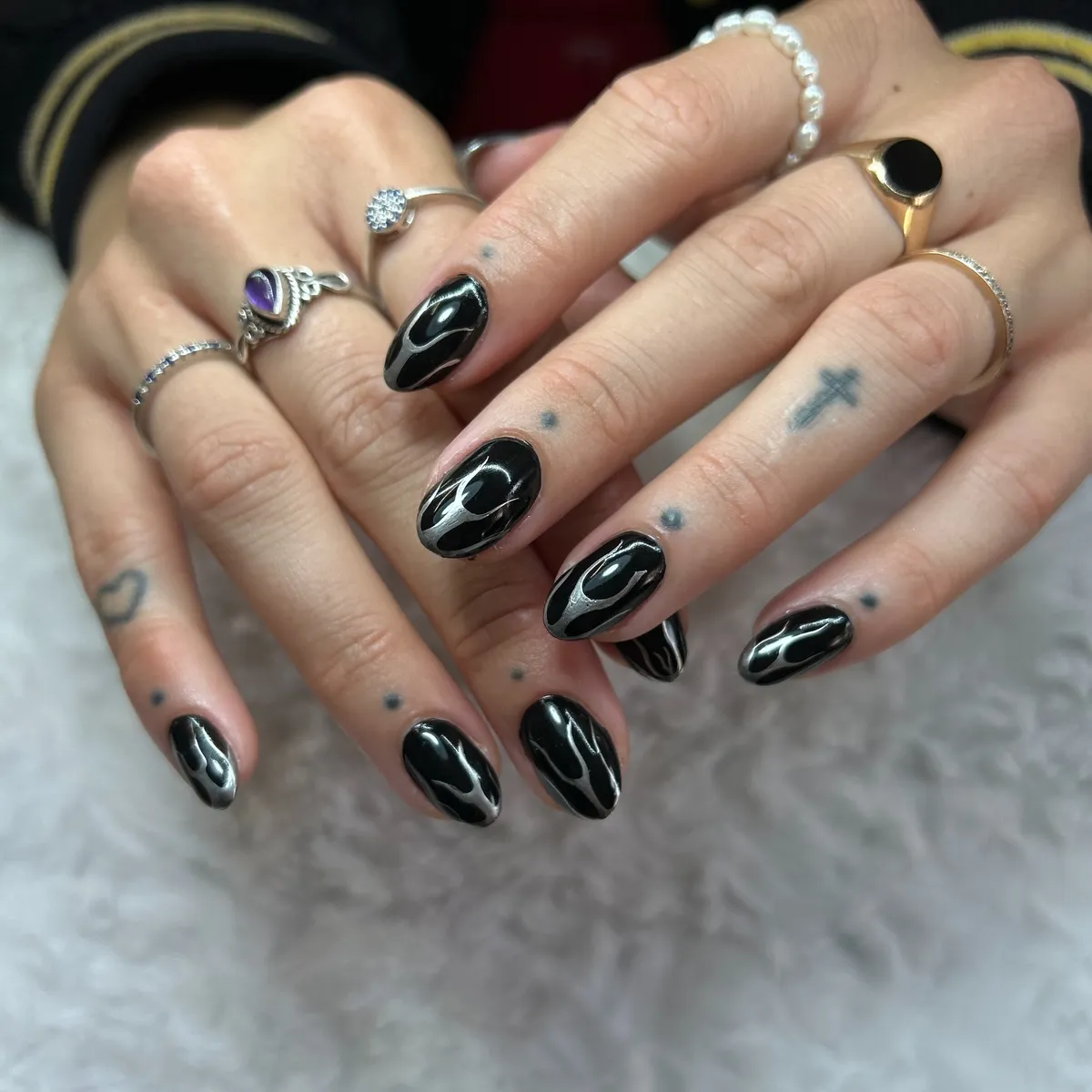 Glossy black almond nails with white flame lines