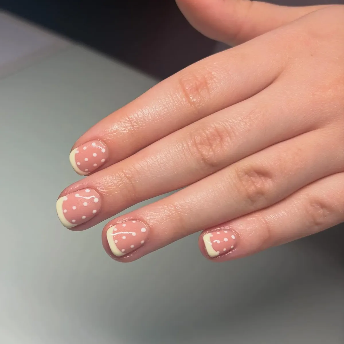 Pink-nude base with pale yellow tips and white polka dots