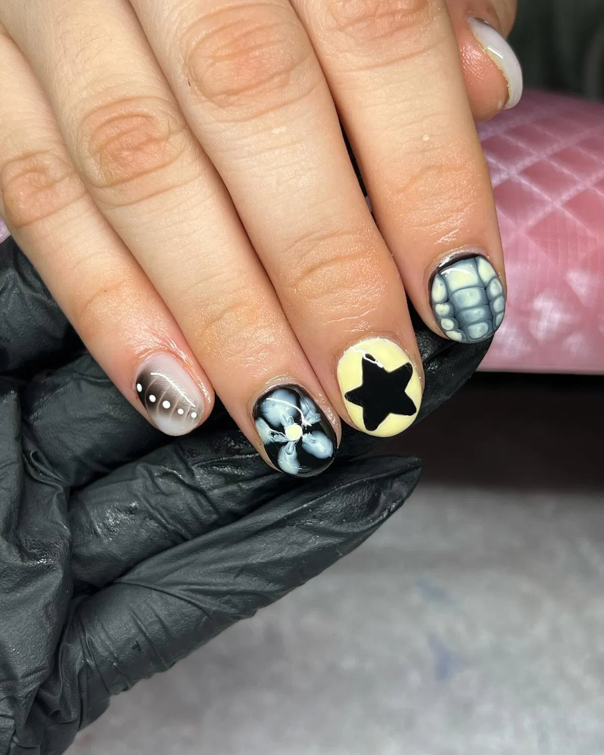 Pale yellow star accent with black/gray graphic nail art