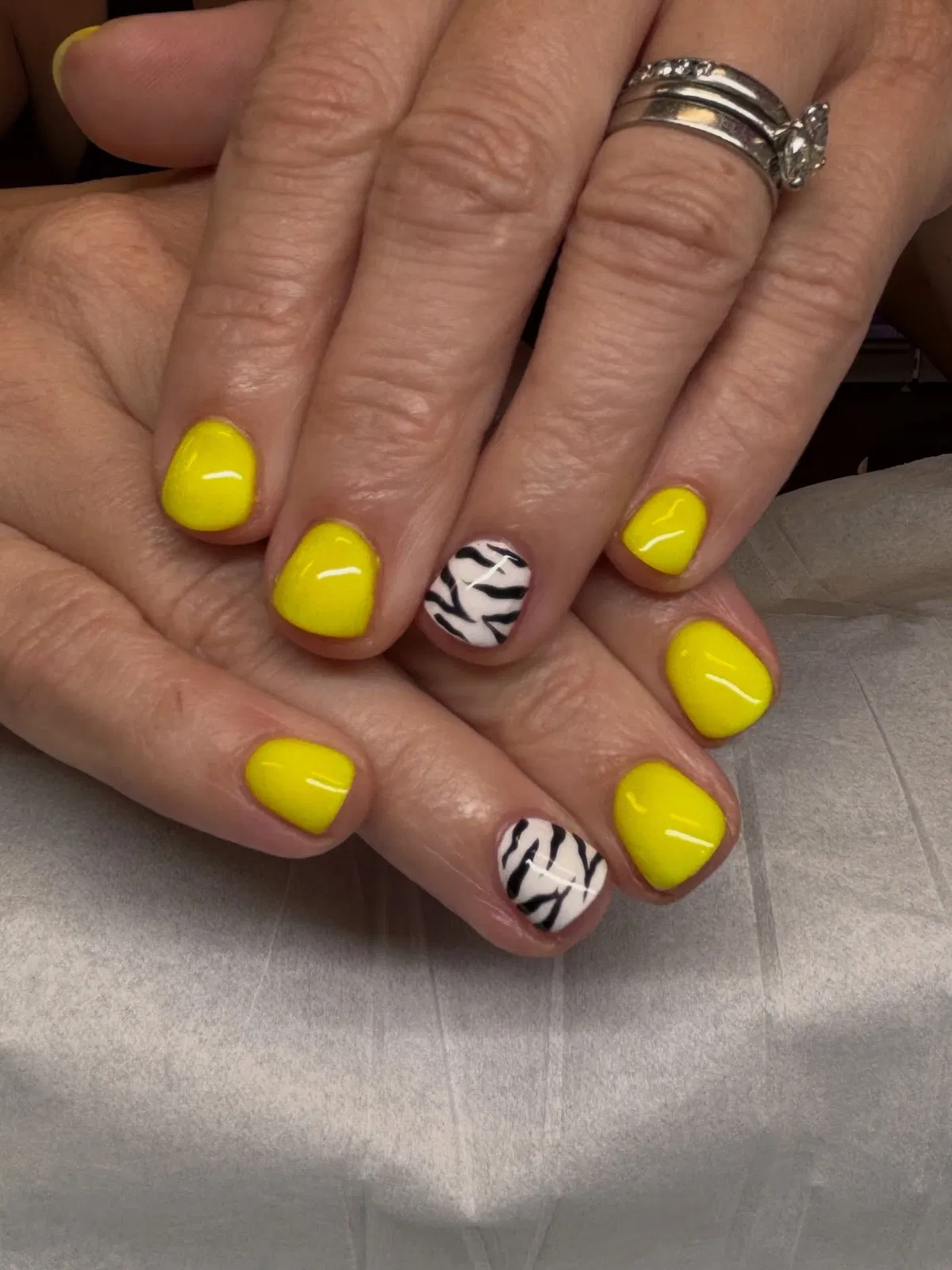 Bright yellow short nails with zebra-stripe accents