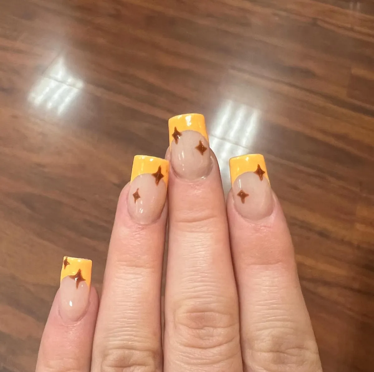 Yellow French tips with small brown star accents