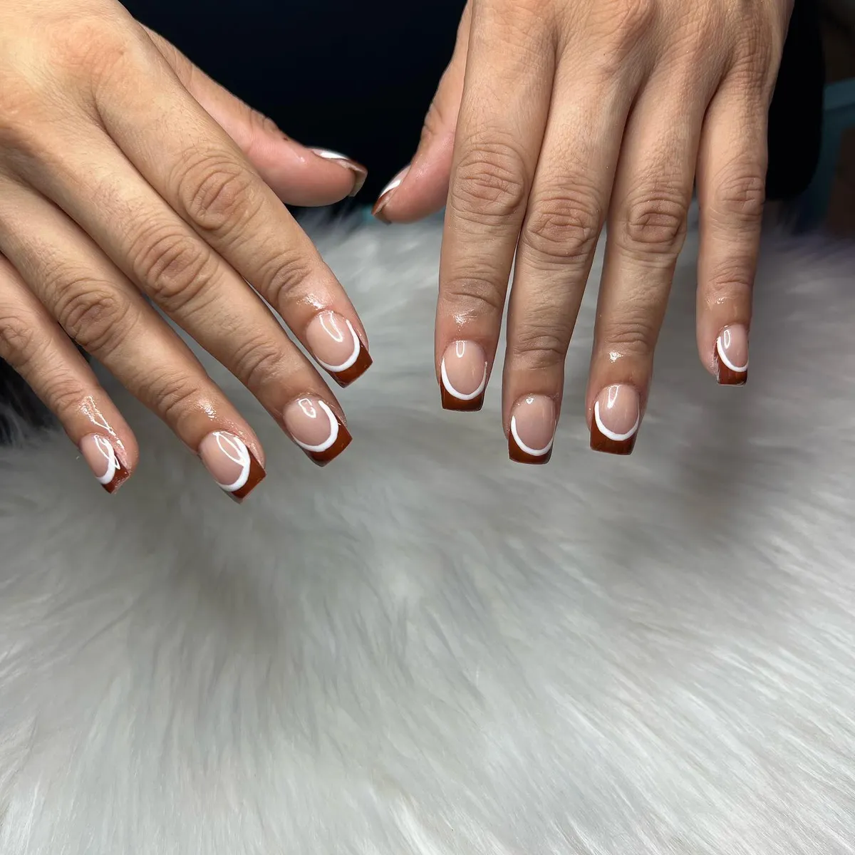 Brown French tips with thin white curved outline