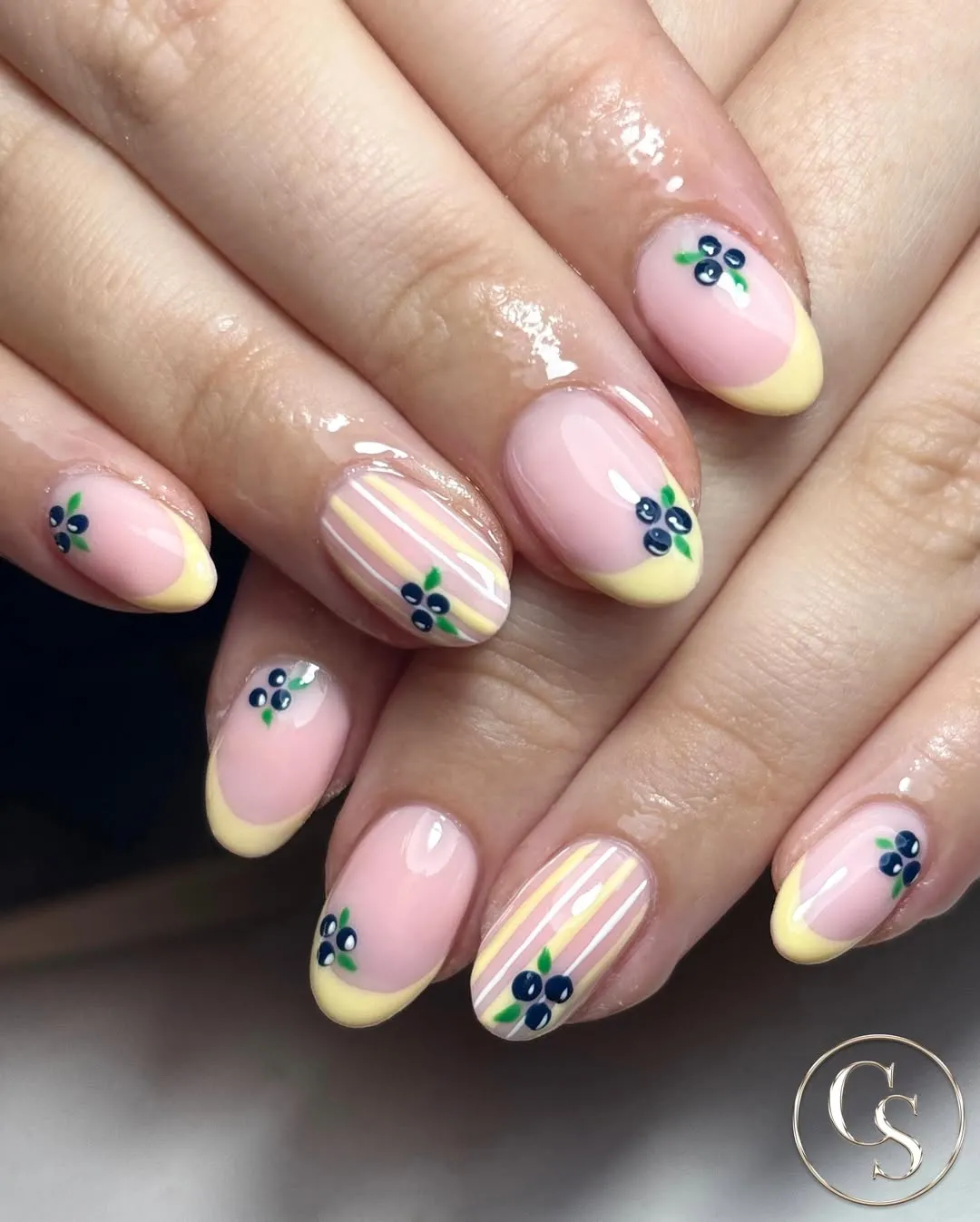 Pale yellow French tips with berry-and-leaf motifs and pastel stripes
