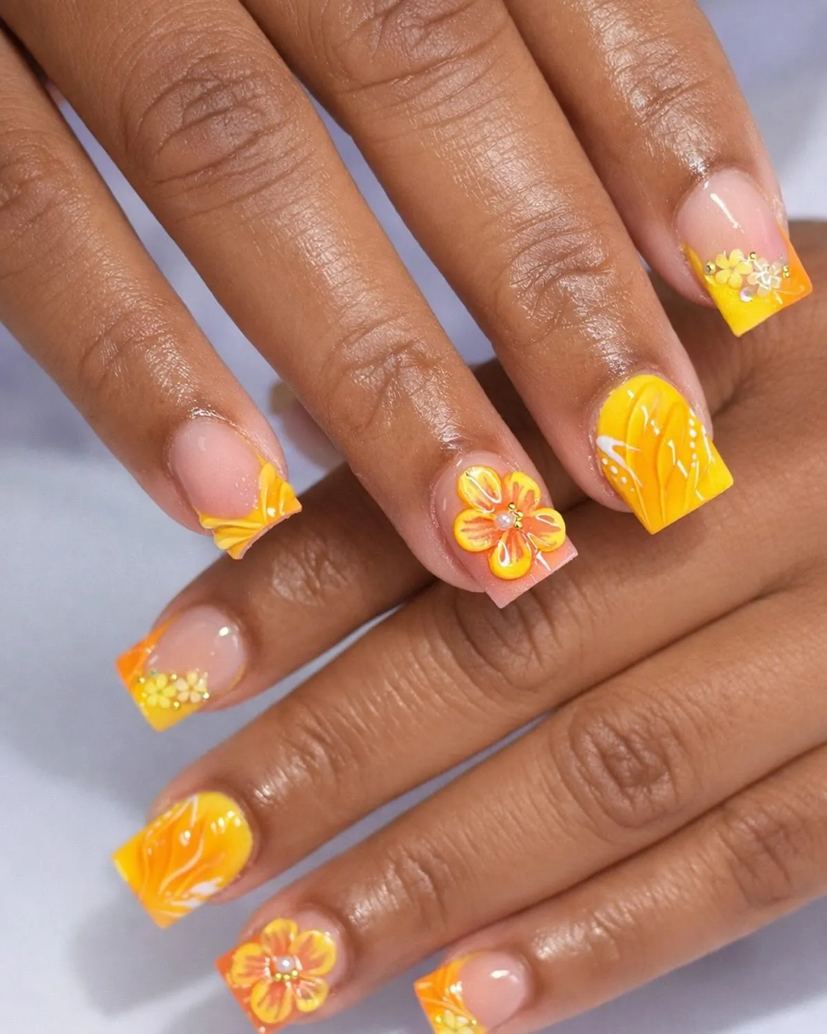 Yellow-orange gradient tips with white swirls and raised floral accents