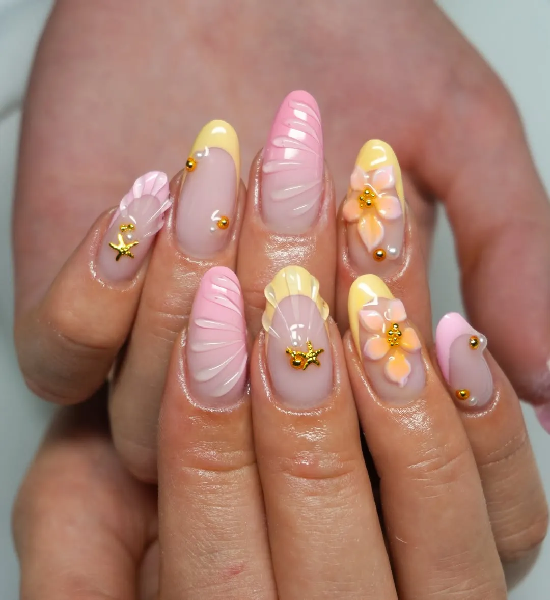 Pale yellow French tips with lace-style accents and gold beading