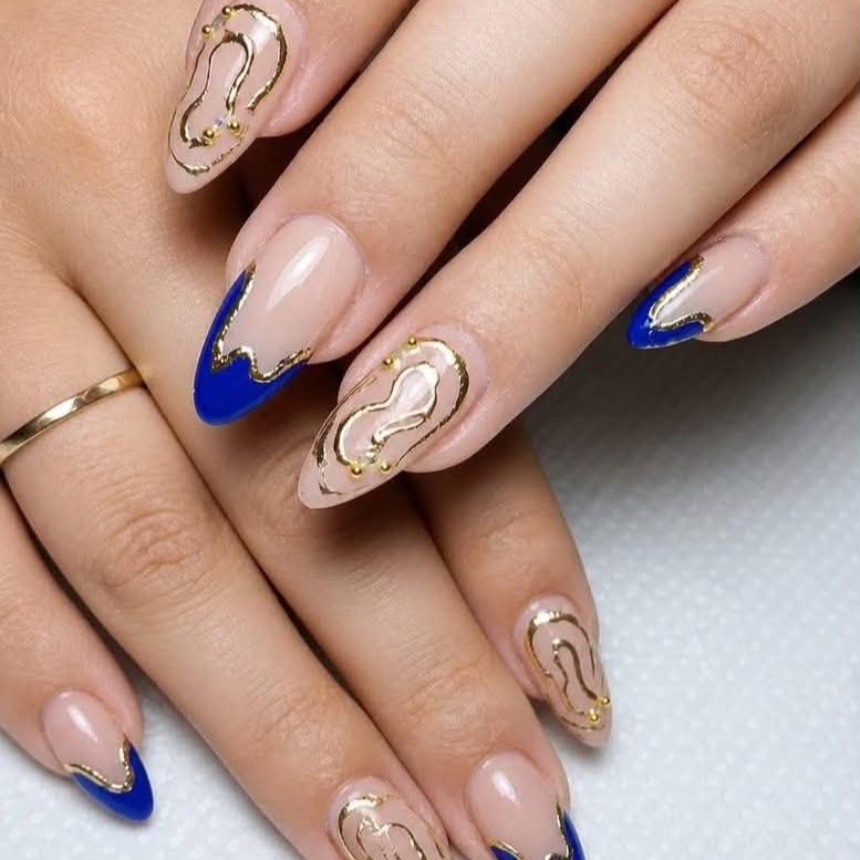 Blue French tips with gold-outlined abstract centers