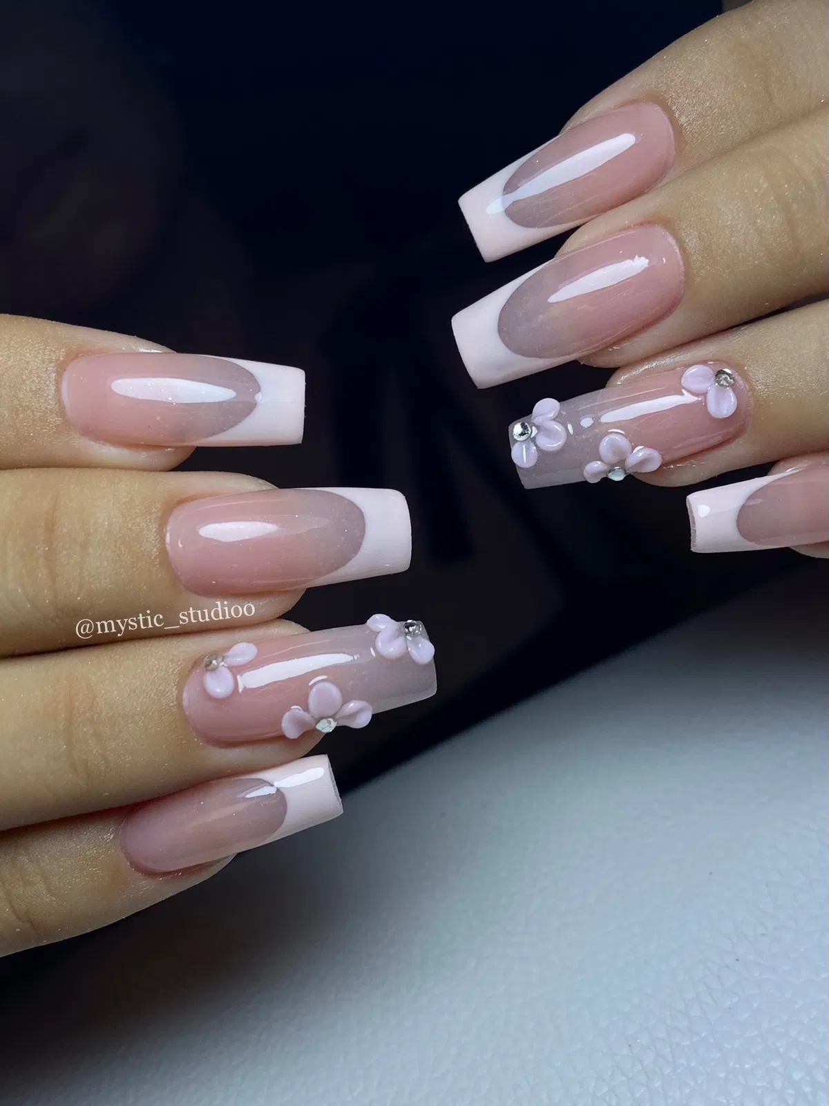 Pale white French tips with 3D pink flowers and rhinestones