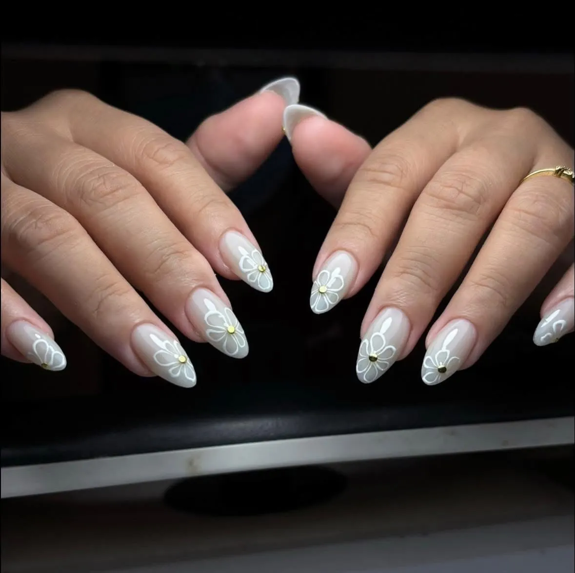 Sheer nude nails with white floral outlines and gold centers