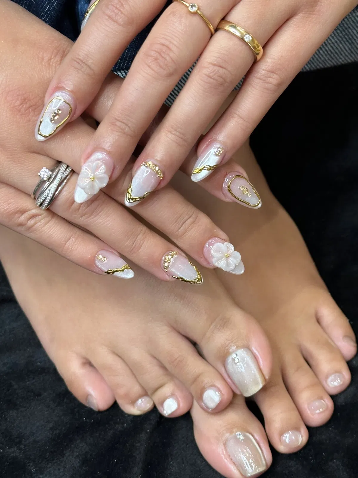Coordinated mani-pedi with white tips, gold edging, and 3D flowers