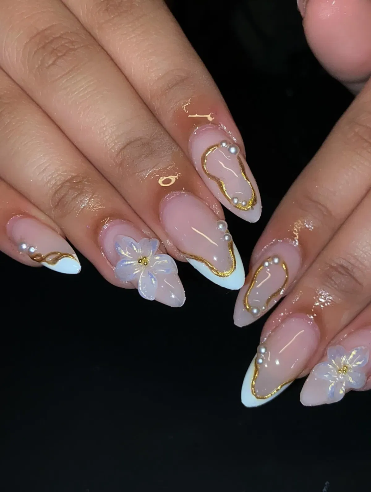 Pearl-accented French tips with gold edging and a 3D flower