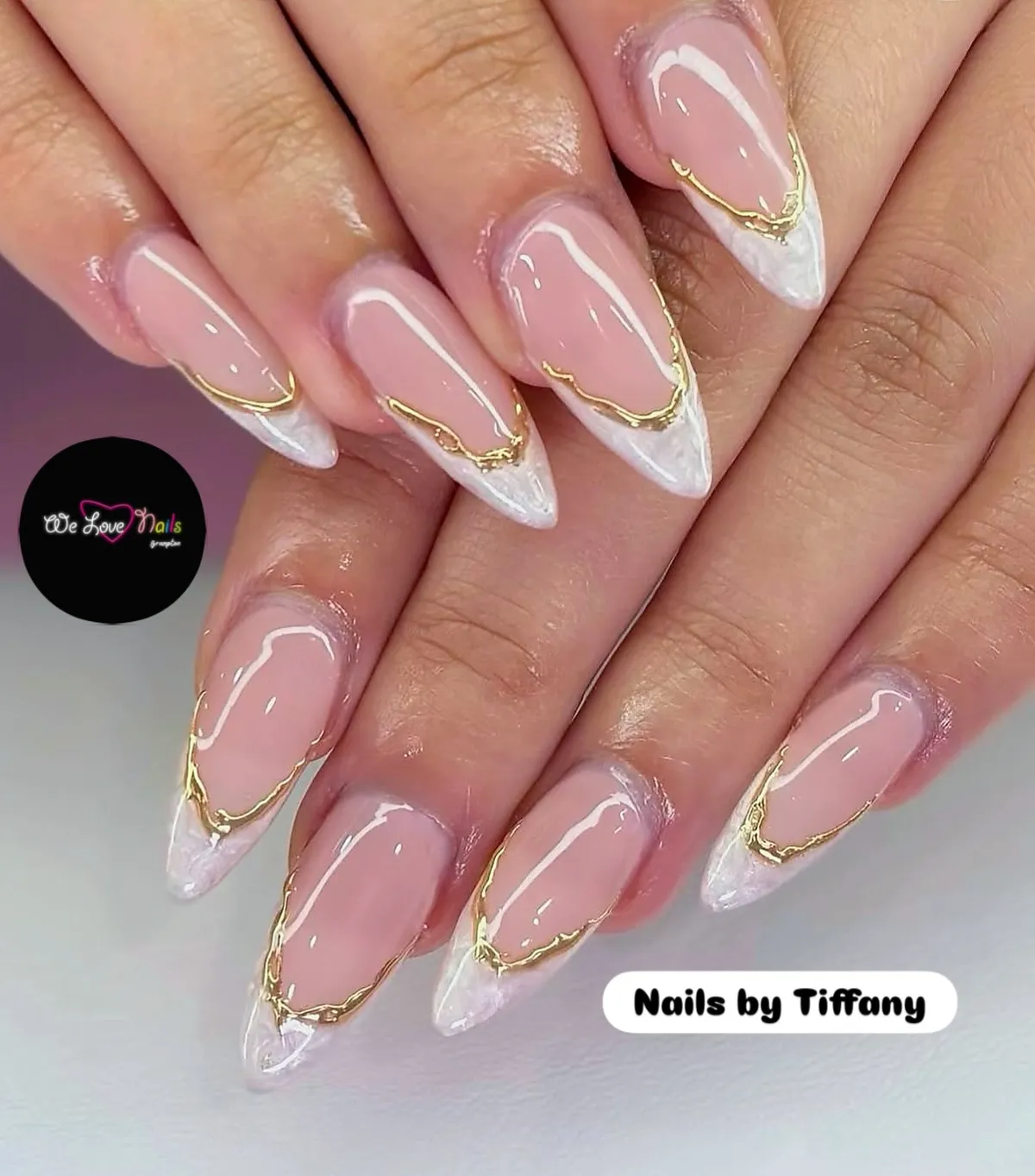 Stiletto nude-to-white tips with irregular gold edging