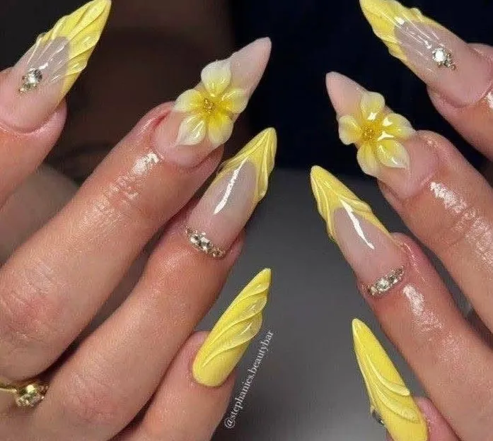 Textured yellow-tipped stiletto nails with 3D flowers and rhinestones