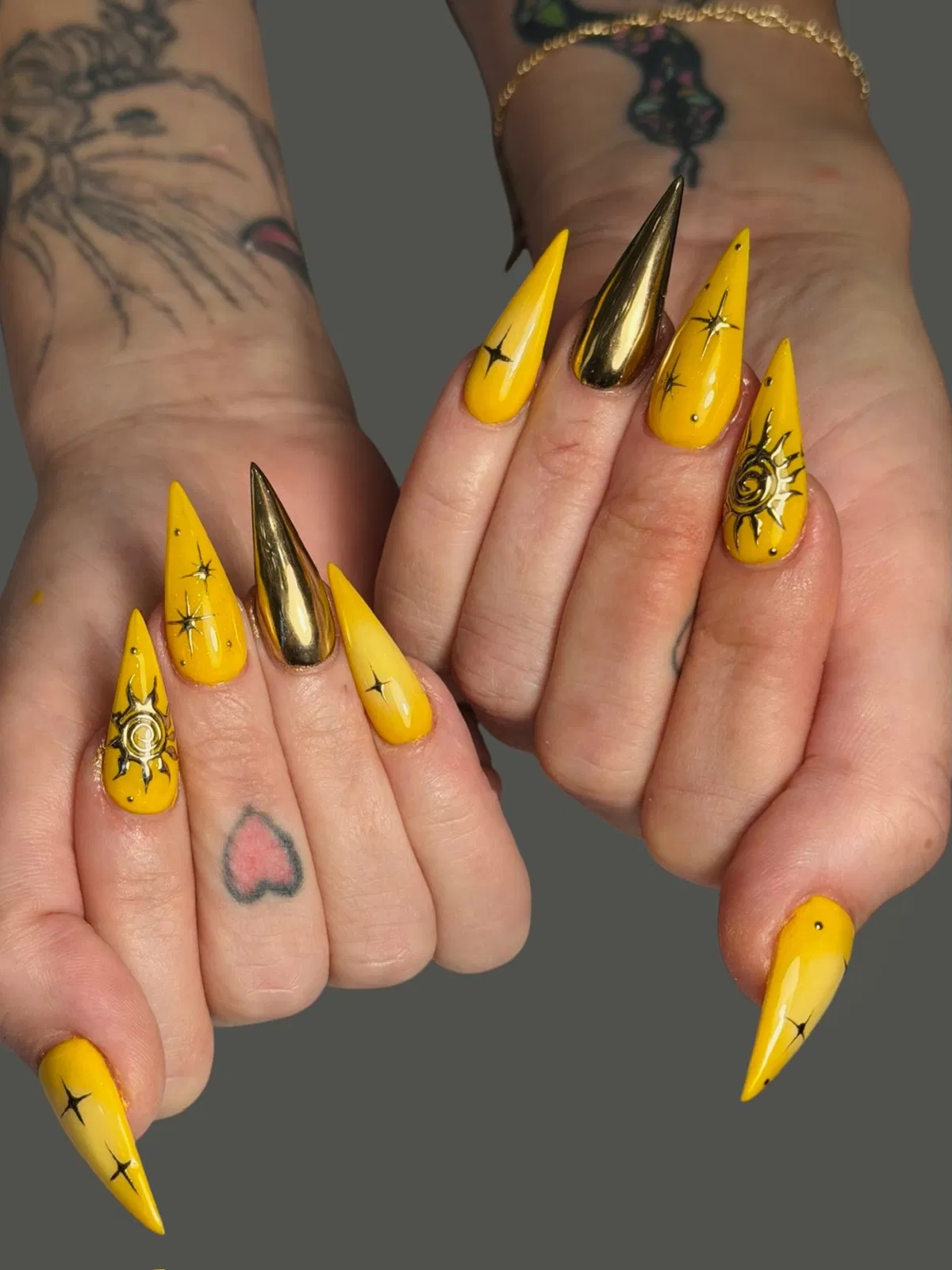 Bright yellow stilettos with gold mirror accent nails
