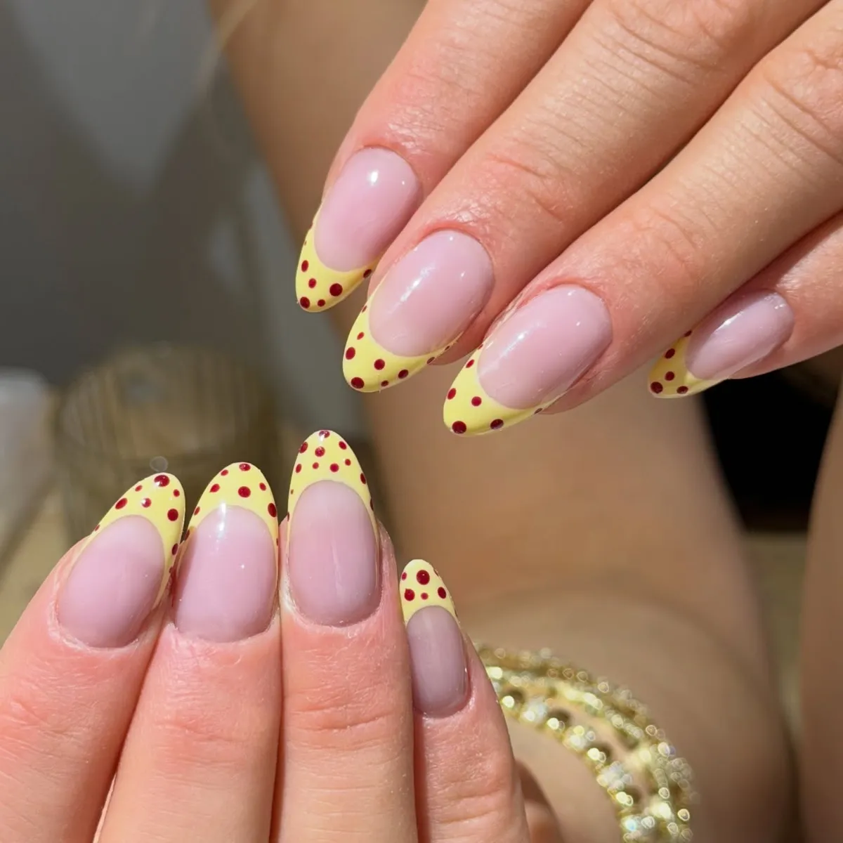 Pale yellow French tips with red polka dots