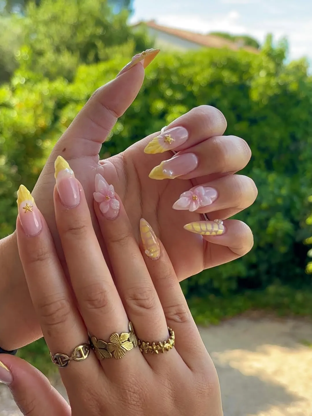 Pale yellow French tips with 3D pink flowers and gold star charms
