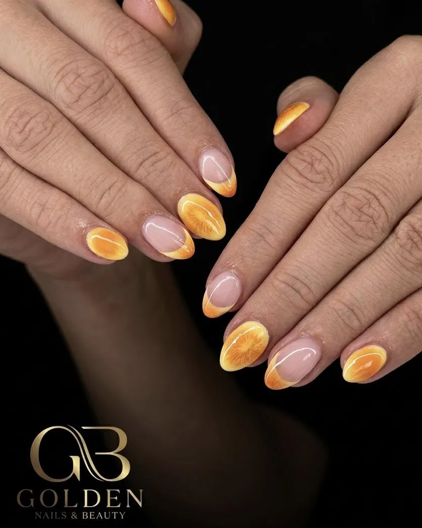 Orange-yellow French tips with citrus-slice nail art