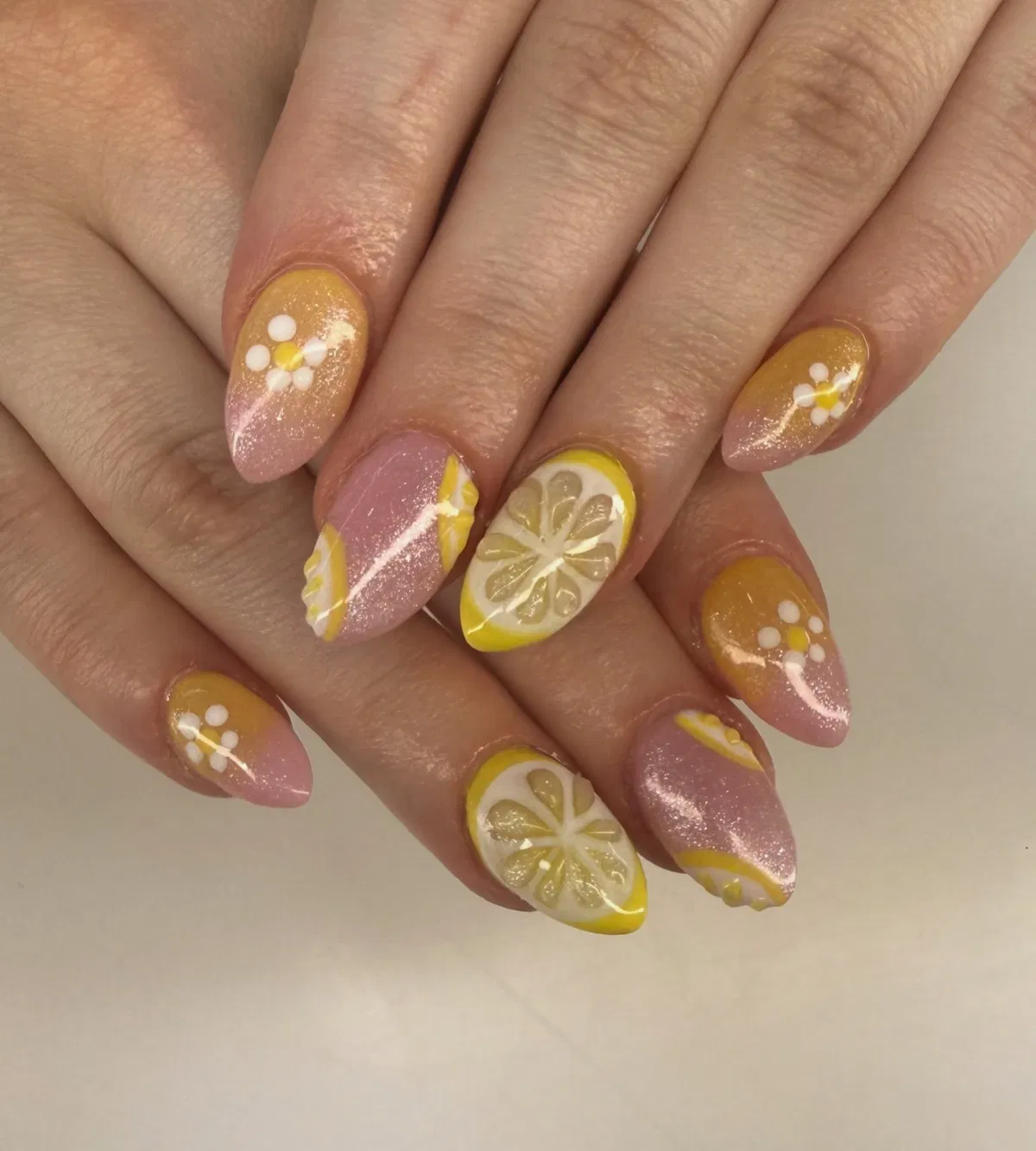 Shimmery pink-to-yellow ombre with citrus slices and small daisies
