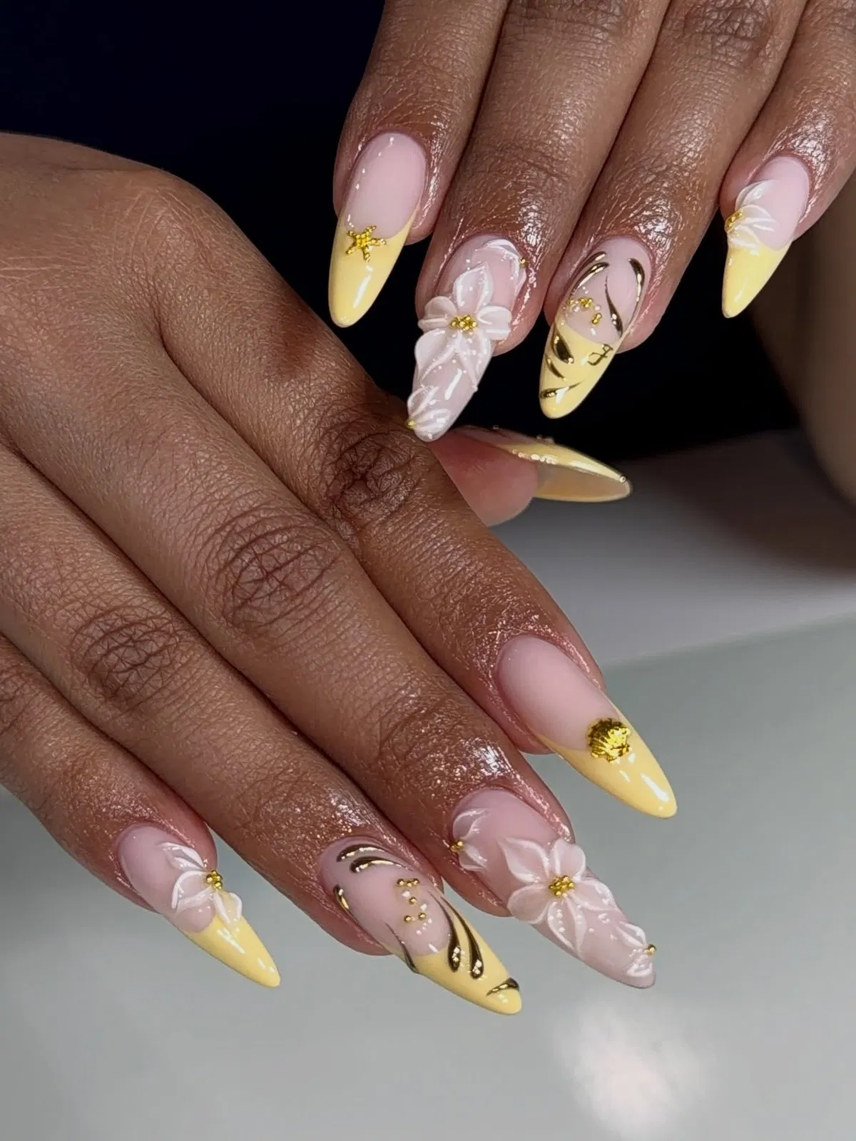 Pale yellow tips with raised white florals and black-gold accents