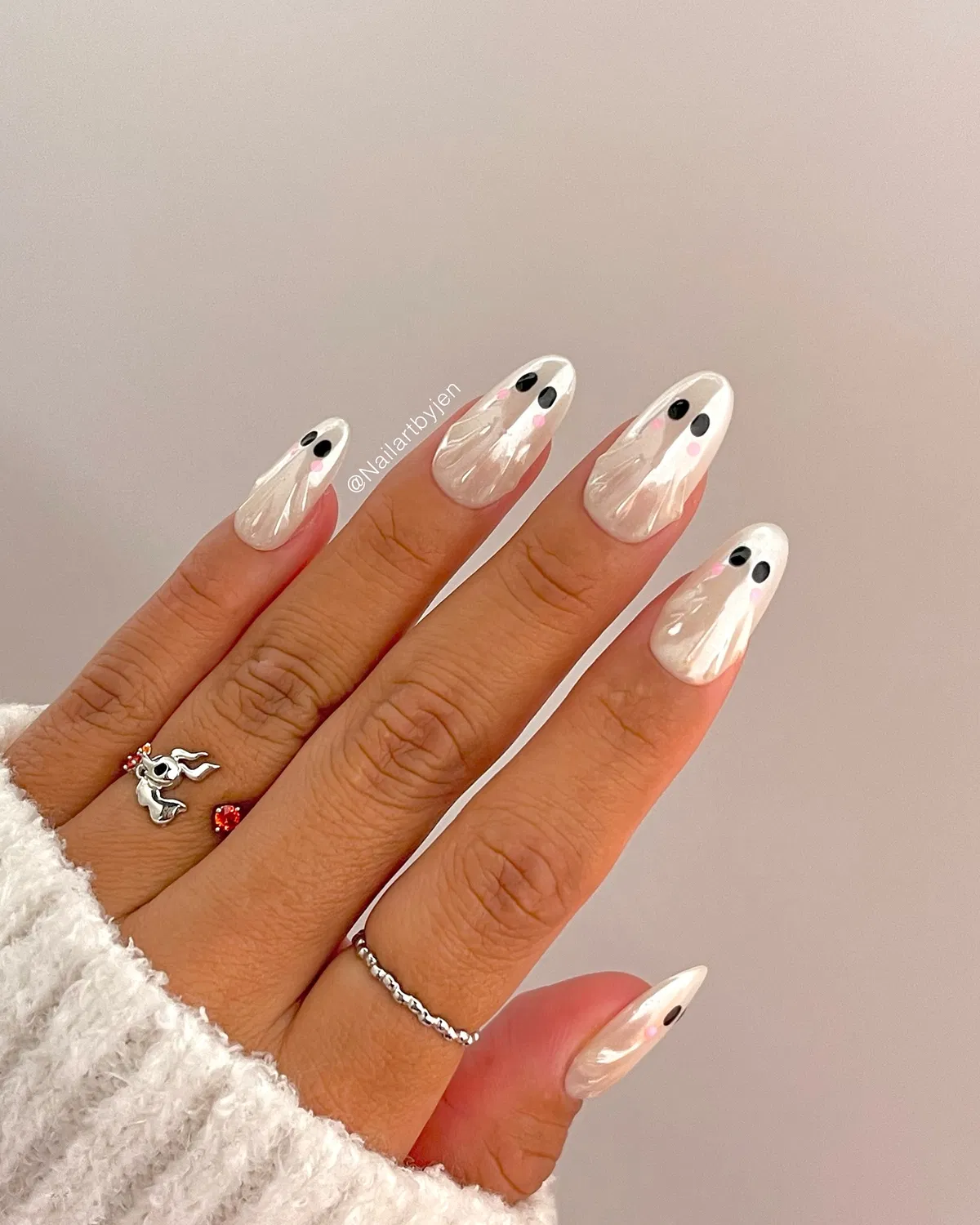 Pearly white nails with black-and-pink face-like dots