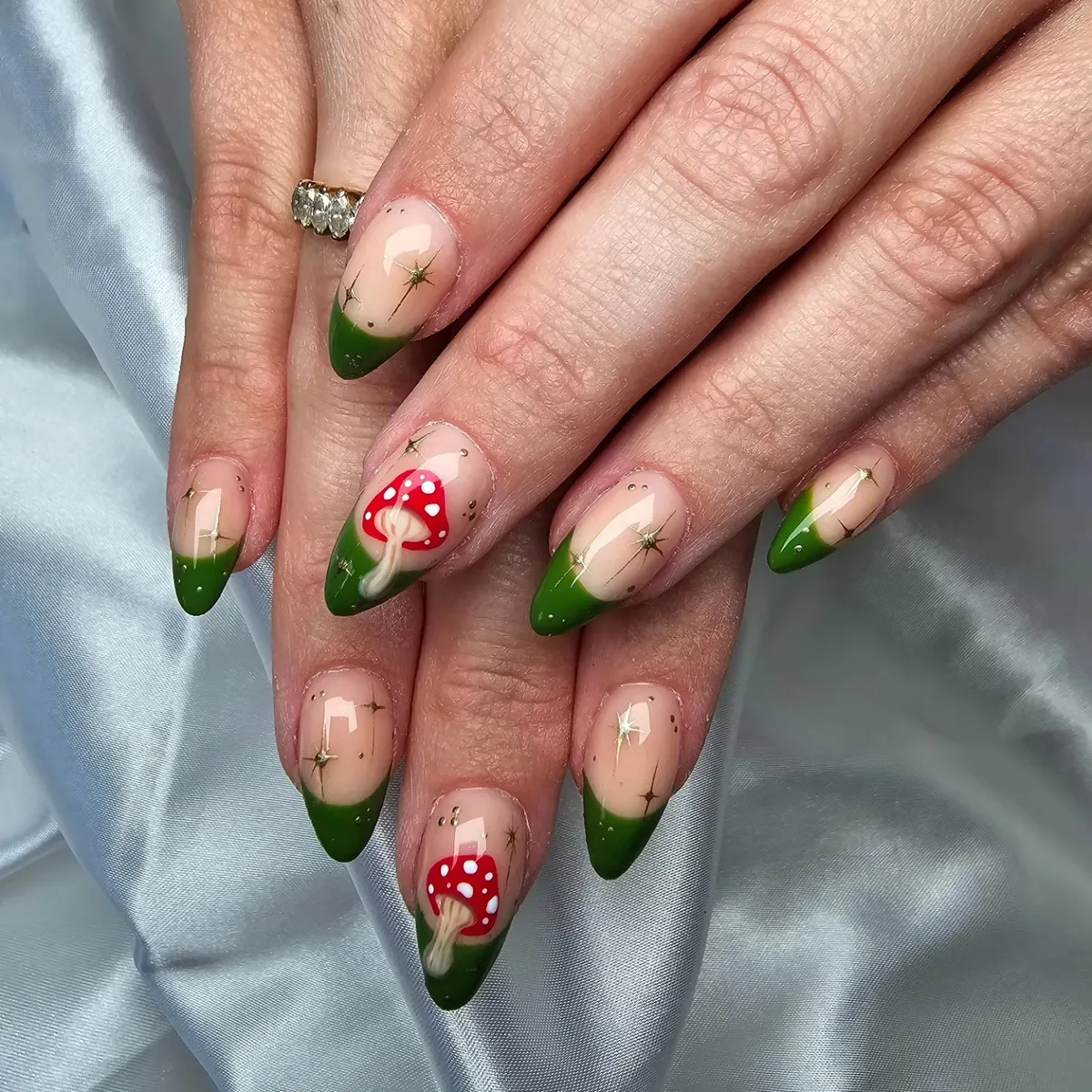 Green French tips with gold stars and red mushroom accents