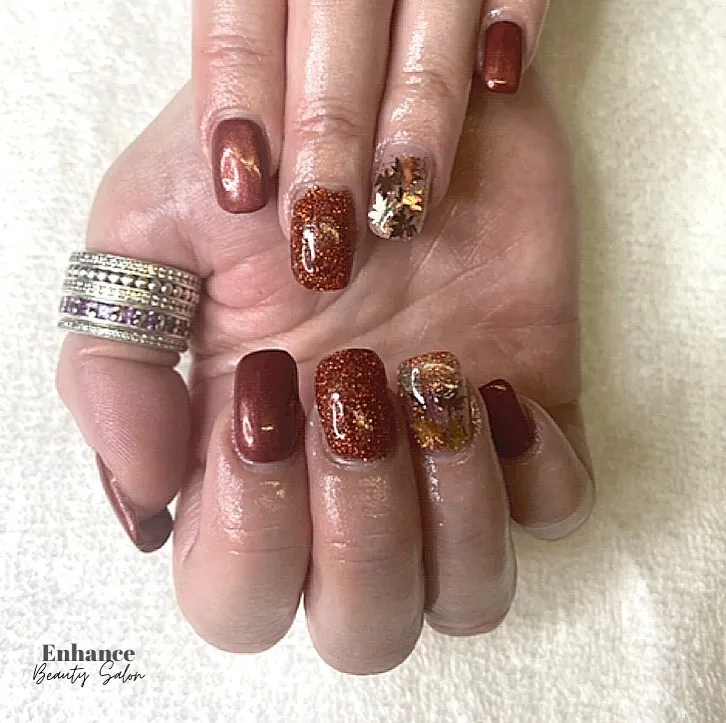 Brown and copper glitter with a leaf-filled accent nail